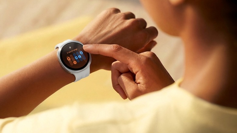 Woman looking a Samsung Galaxy Watch 9 on wrist displaying health data