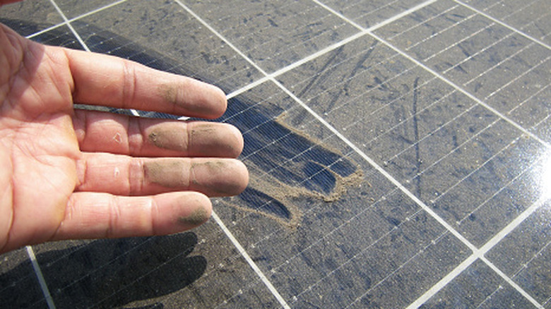 Close-up of a dirty hand after touching solar panels