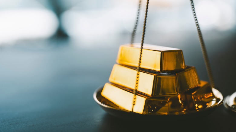 stack of gold bars on an old scale