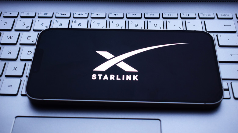 Starlink logo on a smartphone screen that's resting atop a keyboard