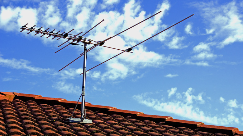 Larger TV antenna installed on the roof of a home with blue sky behind.