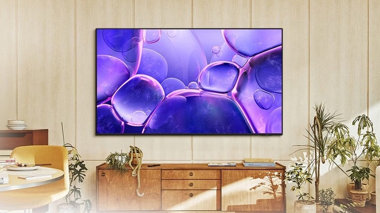 A Samsung Crystal UHD TV mounted to a wooden wall with purple bubbles displayed on screen