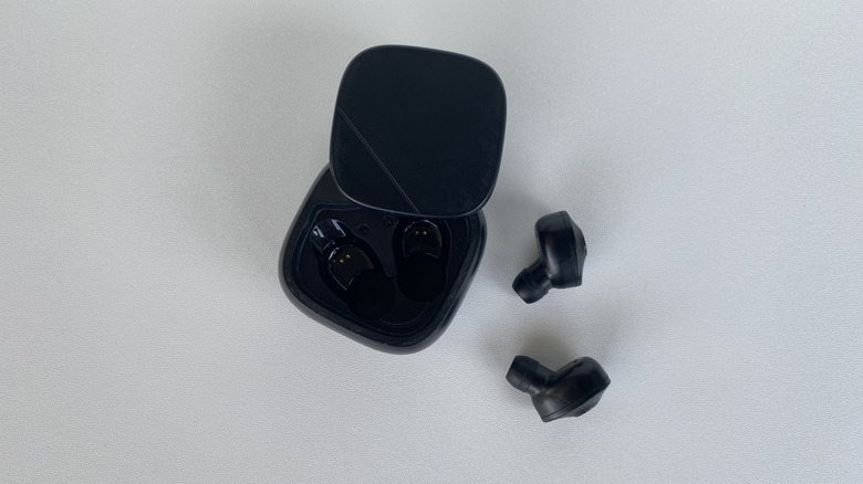 Black earbuds next to their charging case