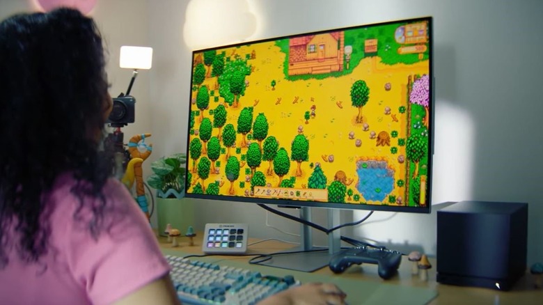 Steam Machine on desk with gamer playing Stardew Valley on screen.