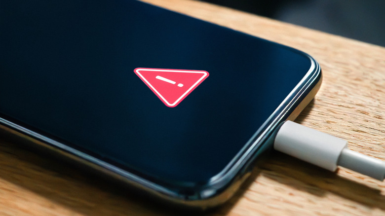 smartphone with red triangle warning suggesting heat issue with smartphone battery when charging