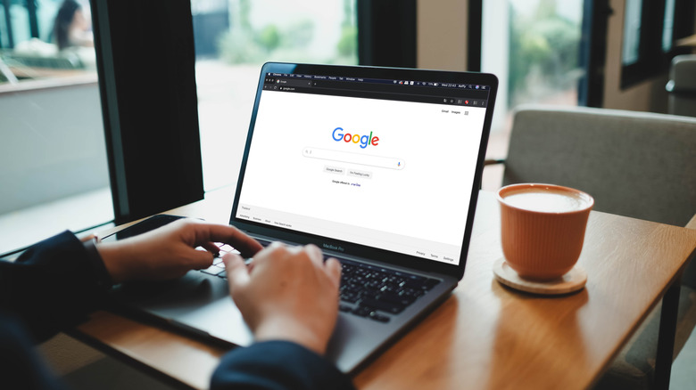 A person accessing Google Search on a laptop.