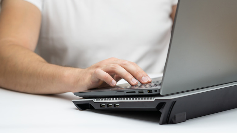 a person using a laptop on a cooling pad