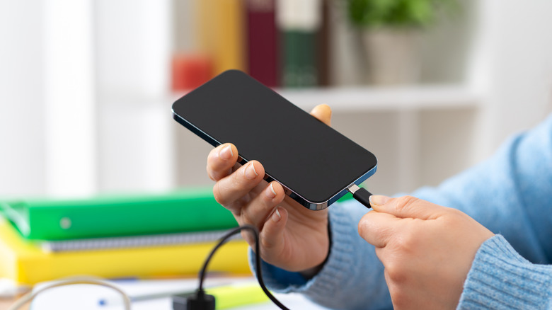 Plugging a USB-C cable into a smartphone