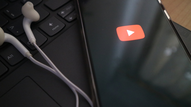closeup smartphone with youtube logo and earbuds