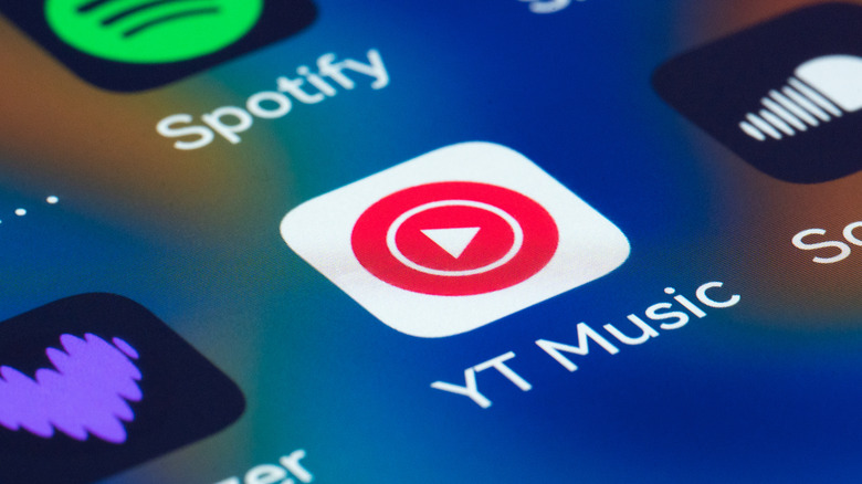 A smartphone screen displaying app icons for YouTube Music and other music streaming services