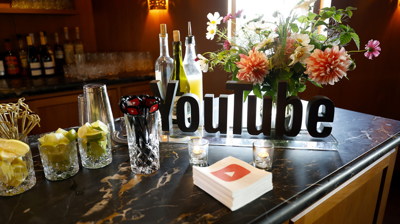 YouTube display on an event table with flowers and napkins