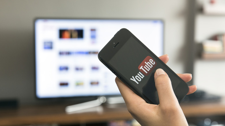 Someone watching YouTube TV with the logo on a smartphone