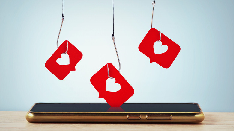 Heart icons on fishing hooks above a smartphone indicating social media 