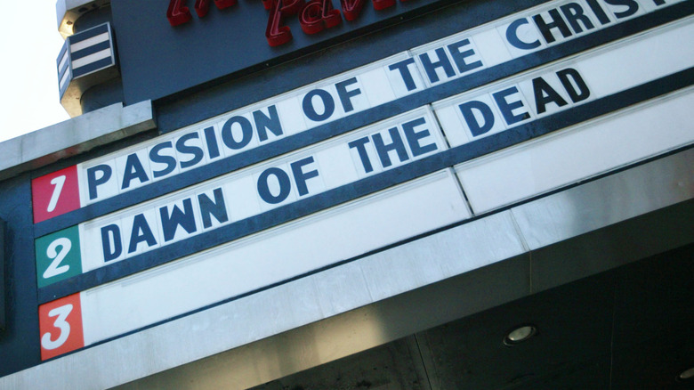 A movie theater sign in 2004 with passion of the christ and dawn of the dead titles visible