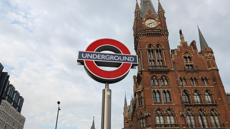 Photo of London Underground sign with old building in the background
