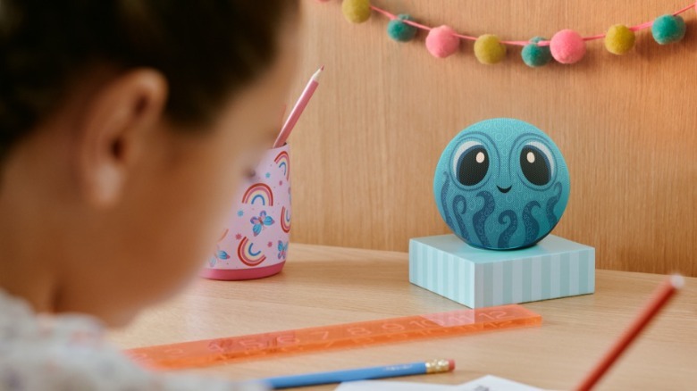 New Kids Echo Dot on a table behind a child